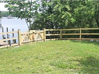 <b>Pressure treated 3-rail ranch rail fence with black mesh and double arched gate</b>